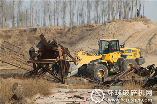 圖為：工作人員正在對非法砂石料場設(shè)備進(jìn)行拆除